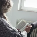 Neues Jahr, neue Bücher - junge Frau entspannt im Sessel und liest ein Buch